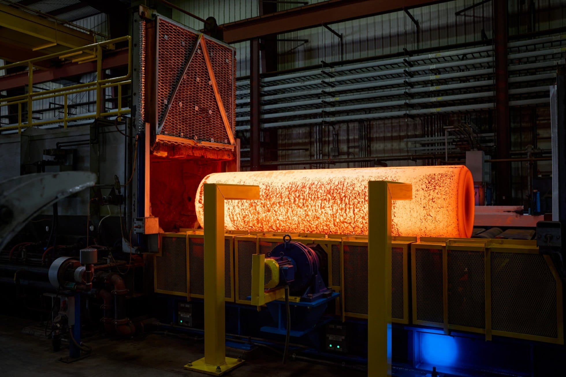 A glowing cylinder of hot titanium moves through a Perryman Company foundry