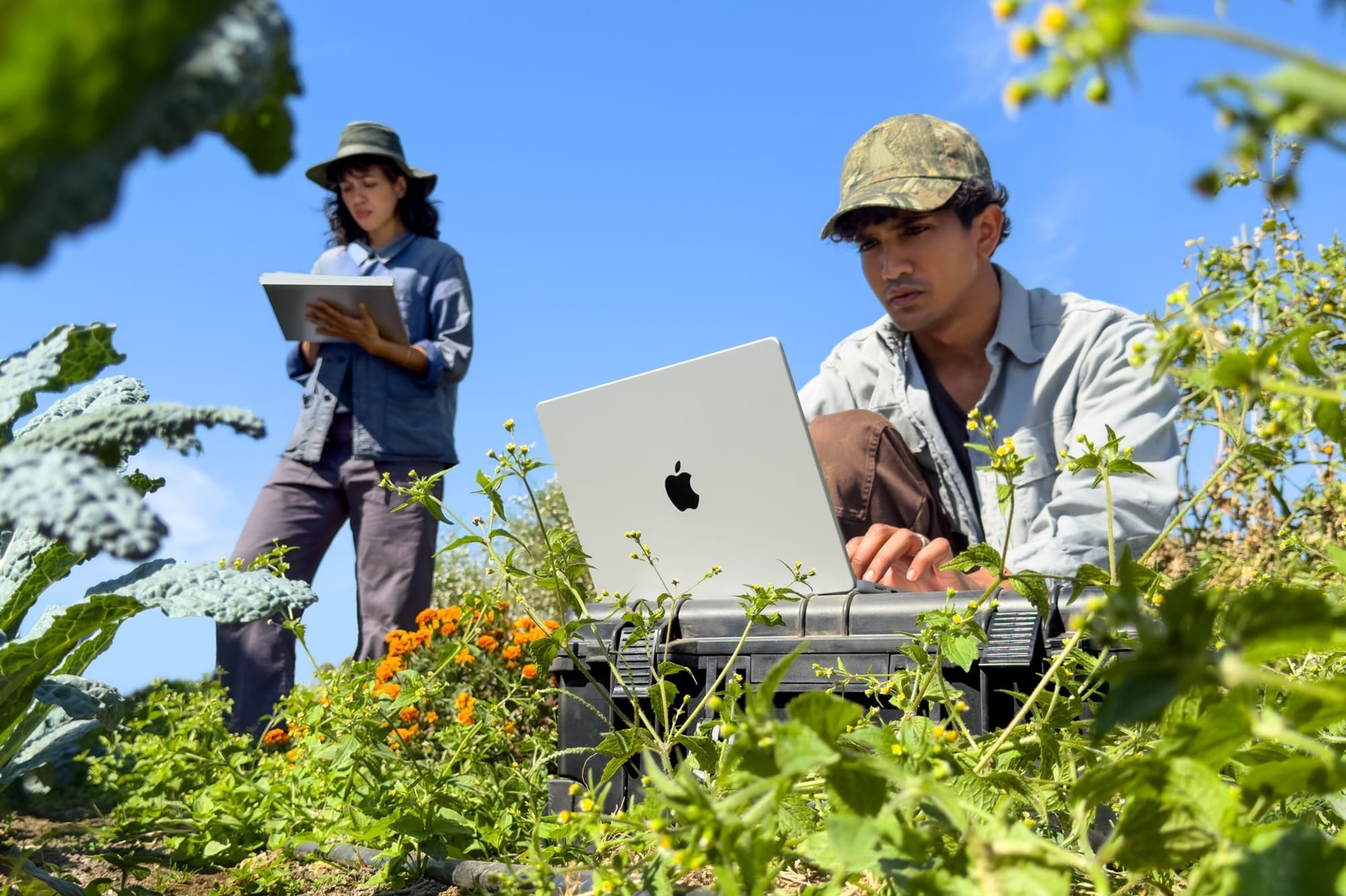 Two people working outdoors on the 14-inch MacBook Pro with M6