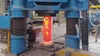 A glowing titanium billet in a forging press at a Perryman Company facility