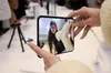 A customer frames a selfie on an iPhone Duo's outer display