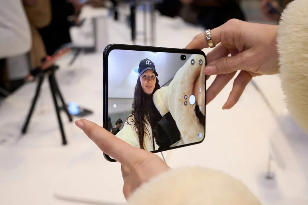 A customer frames a selfie on an iPhone Duo's outer display