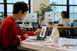 A person touching the PROLED XDR display on the new MacBook Pro